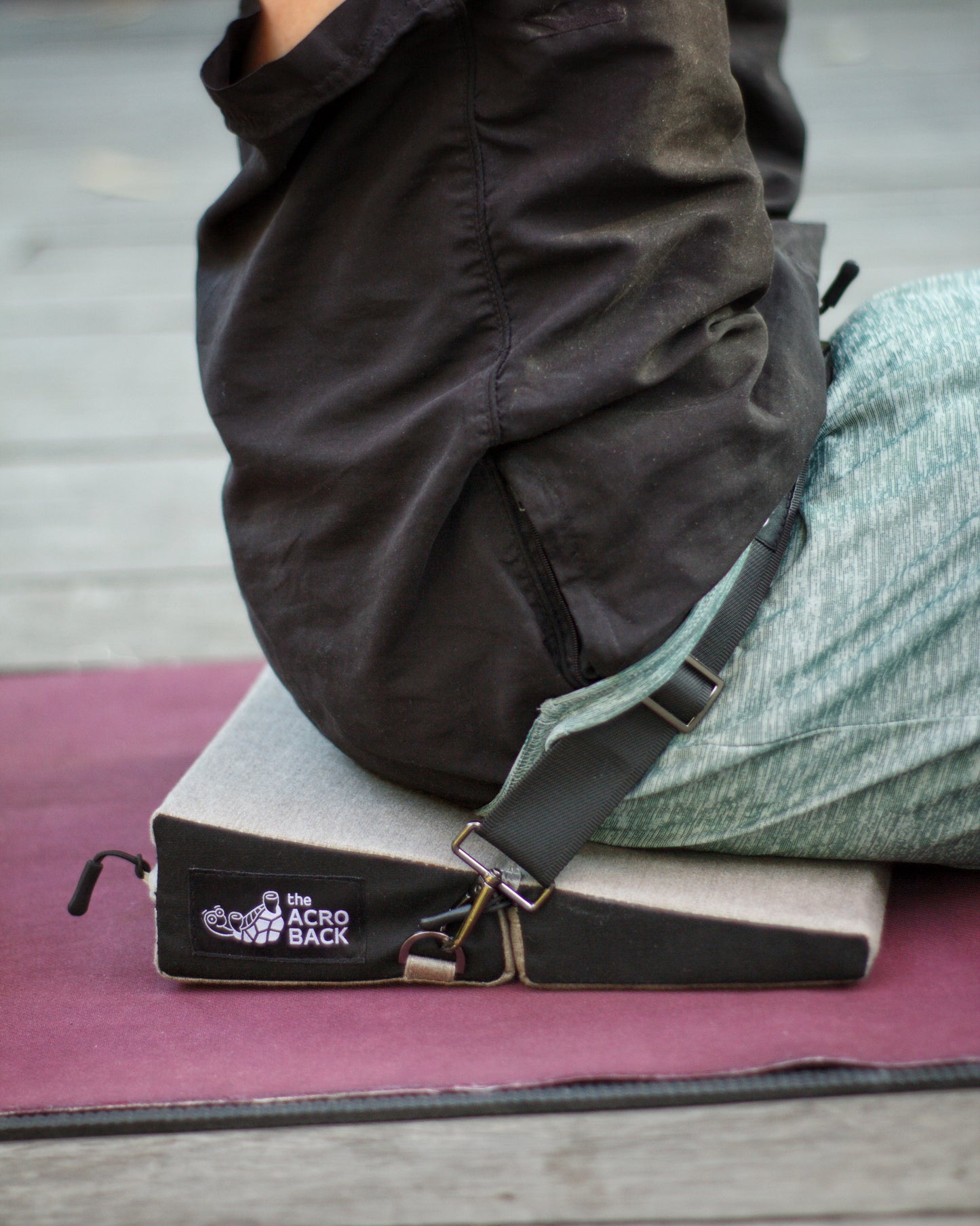 The AcroBack Big Poppa XL carried by AcroYogi showing shoulder strap portability system and large format support pillow