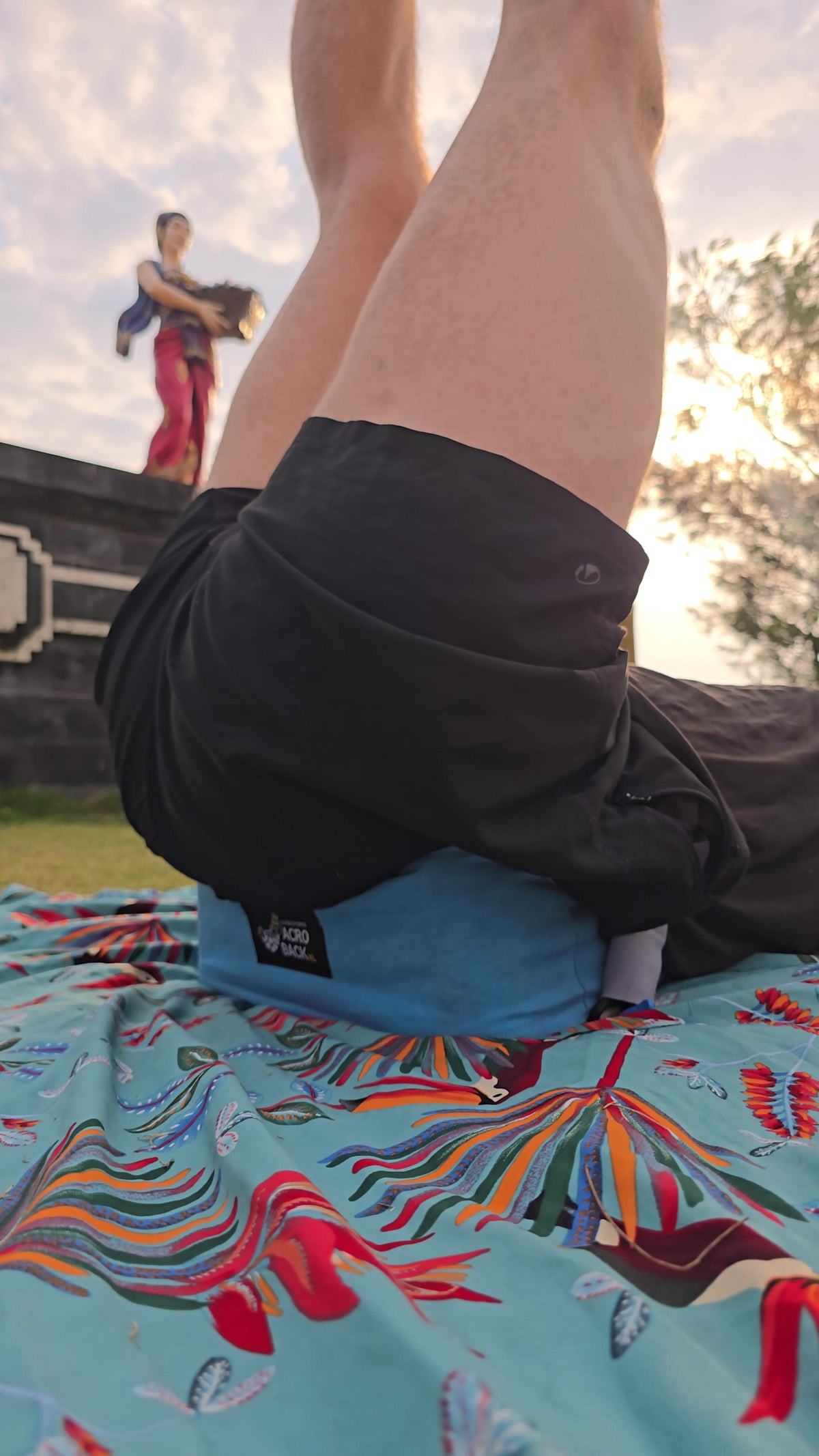 AcroBack azul apoyando las caderas de una base durante práctica al aire libre