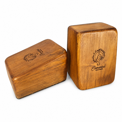 Pair of angled Elemental teak handstand blocks showing the top and side surfaces on a white background.